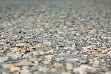 The old road, small stones and asphalt close up with a small depth of field.