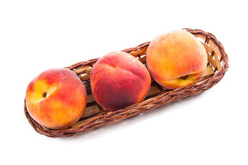 Group of ripe peach fruit in basket isolated on white background.