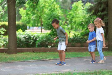 Obraz premium Little children playing hopscotch, outdoors
