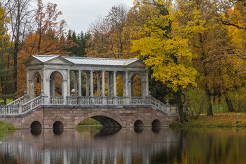 Fototapeta na wymiar Autumn forest in Pushkin, marble bridge, Saint-Petersburg, Russia