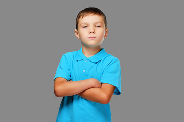 Studio portrait of a teenage boy with crossed arms.