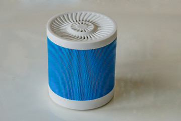 Close-up of a portable speaker on a white background connecting to a smartphone. Concept Technology.