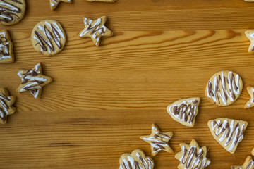 Gingerbread Christmas cookies, on a kitchen table, glazed with chocolate and sprinkled with powdered sugar, diffrent shapes. Concept Christmas.