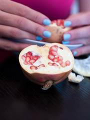 Young woman peeling pomegranates