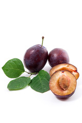 Group of whole and half of ripe plums with leaf isolated on a white background..