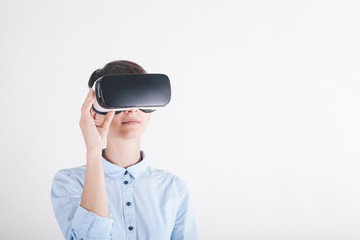 girl in virtual reality headset on white background looking up