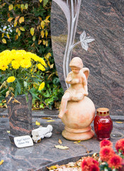 Kleiner Engel mit Grablichter und Blumen