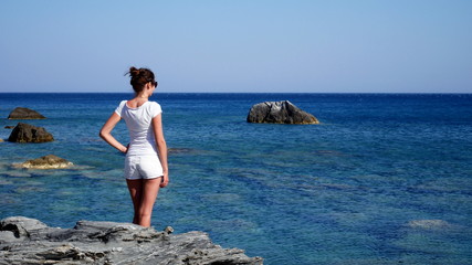 Europe's Secret Islands/ Woman staying on the rock looking the sea.