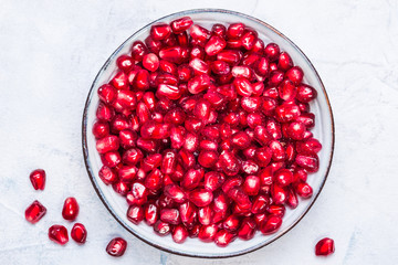Pomegranate seeds in a bowl top view.