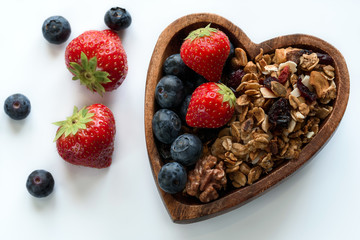 Healthy breakfast: homemade gramola with fresh blueberry and strawberry on white background