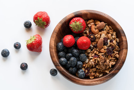 Healthy breakfast: homemade gramola with fresh blueberry and strawberry on white background