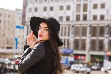 Fototapeta premium Styl życia portret ładny model brunetka w modnym płaszczu i kapeluszu, pozowanie na ulicy miasta