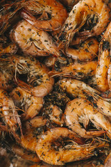 Shrimps on black background. Delicious seafood appetizer served boiled or grilled with spices. Close up. Top view