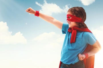 Composite image of happy boy in red cape