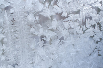 Winter background. Frosty pattern on window pane with strips and big snowflakes.