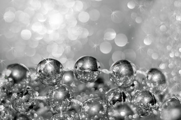 Abstract silver christmas black and white background with soft focus. Thread with round beads and beautiful bokeh.