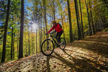 Peel and stick wall murals Bicycles Cycling, mountain bikeing woman on cycle trail in autumn forest. Mountain biking in autumn landscape forest. Woman cycling MTB flow uphill trail.