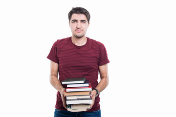 Portrait of handsome student posing holding pile of books