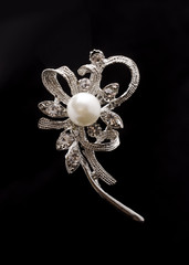 Silver brooch with pearl isolated on black