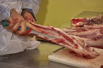 Butcher cleaning the meat from impurities