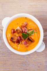 Butternut Squash and Bacon Soup in White Bowl. View from above, top studio shot, vertical