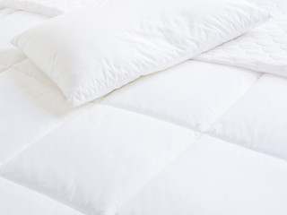 Closeup of white pillow and topper bed.