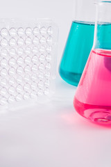  research, science and clinic background. 96 well micro plate and  laboratory beakers with colorful...