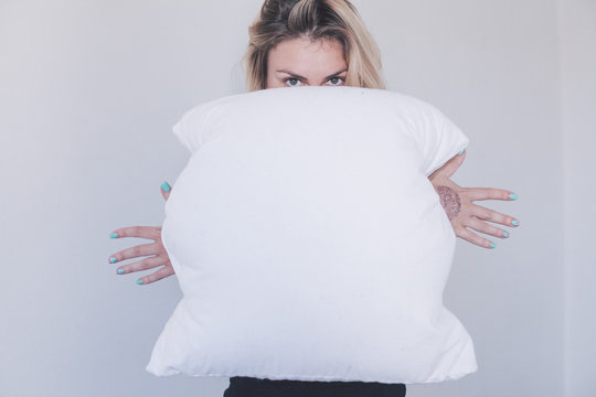 girl holds white pillow