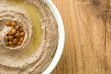 Lentil hummus in bowl on wood