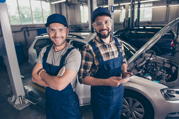 Automotive breakdown, wi fi internet concept. Cheerful experts at work shop, standing in blue...