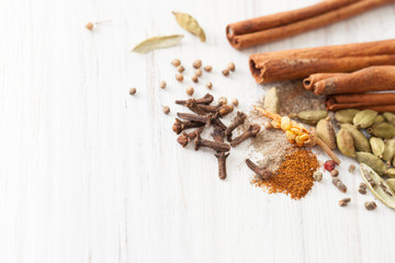 Cloves, cinnamon close-up on white table