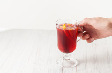 Full glass of mulled wine on white wooden table