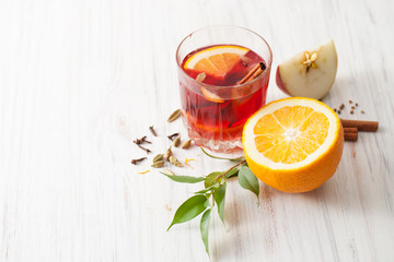 Mulled wine with slice of orange and Apple on a white table