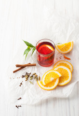 A glass of mulled wine with sliced oranges and cinnamon
