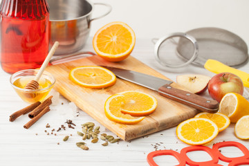 Cut the oranges and spices for mulled wine on a white table