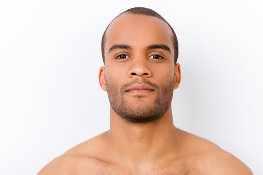 Hygiene, vitality, beauty, men life concept. Close up portrait of afro young nude guy with stubble isolated on pure white background, harsh and virile