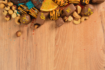 Chocolate sweets with orange slices and dried fruits on a wooden table. handmade?