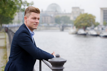 blond man with german parliament in the background