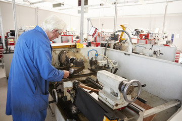 Senior engineer working in a factory, back view