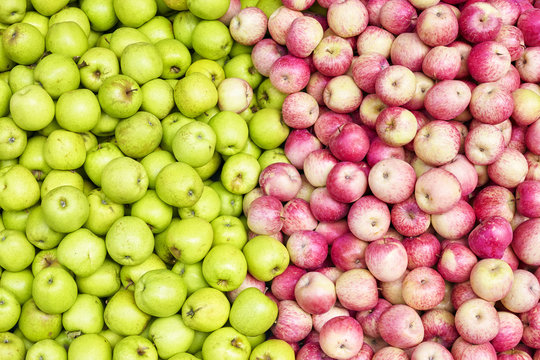 Red and green apples on a local market, fruit background.