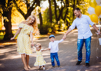 Fototapeta premium Amazing parents have fun with their two children walking in the park