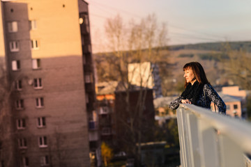 the woman is standing on the bridge near the handrail