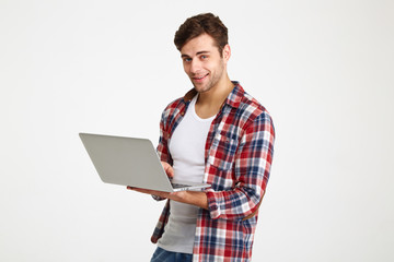 Portrait of a smiling young man holding laptop computer