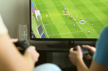 Two guys playing imaginary multiplayer soccer or football video game with console and tv. Guys...