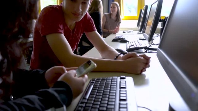 Sch&uuml;lerin schaut auf das Mobiltelefon mit Banknachbar