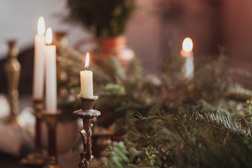 Festive Christmas table decoration arrangement with burning candles and fir branches