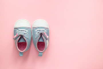 Children's denim sports shoes for girls, stands on a pink background. closeup view from the top. the concept of children's clothing