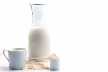 Bottle of fresh milk with powdered milk and spoon for baby on white background.