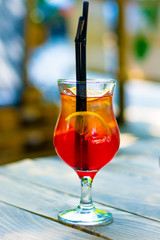 cold cocktail in a glass glass with ice slices of lemon and black tubules