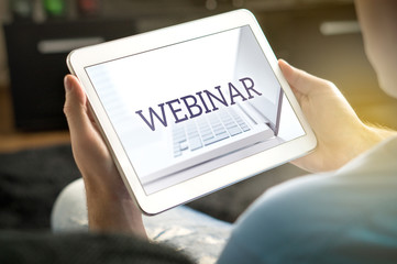 Webinar on tablet screen. Man holding smart mobile device and participating in a web seminar.